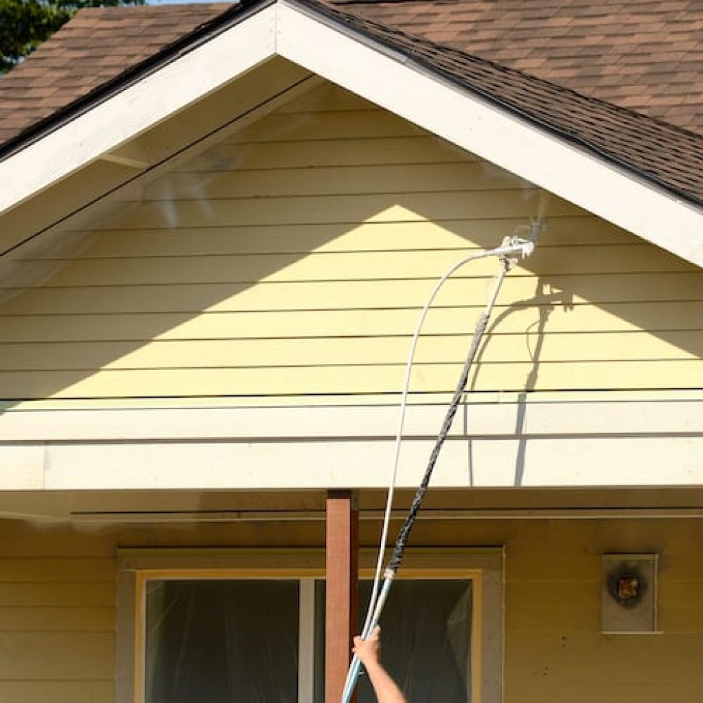 Painting outside of a yellow house
